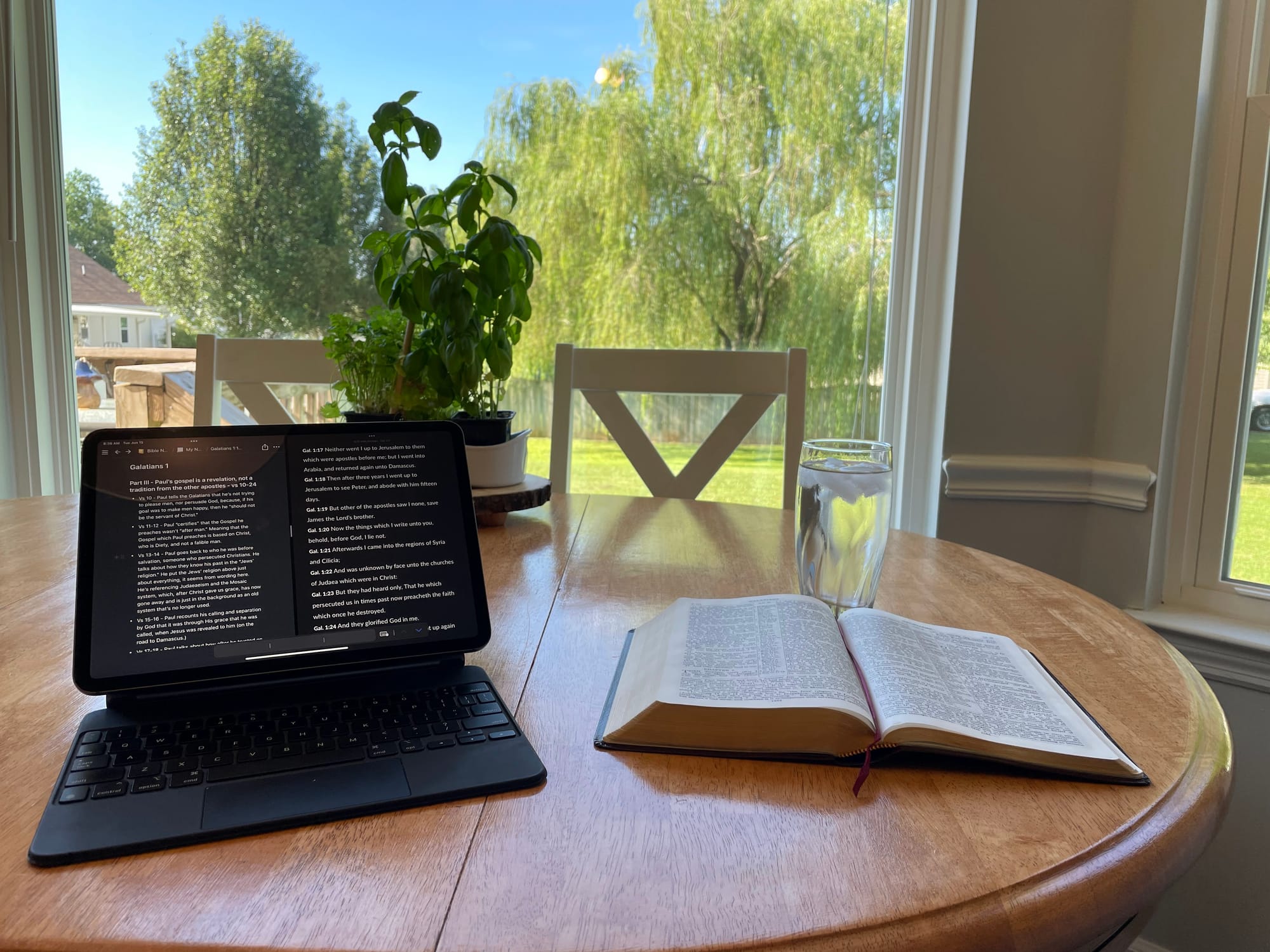 An iPad and Bible sitting on a table, open with notes on the screen.