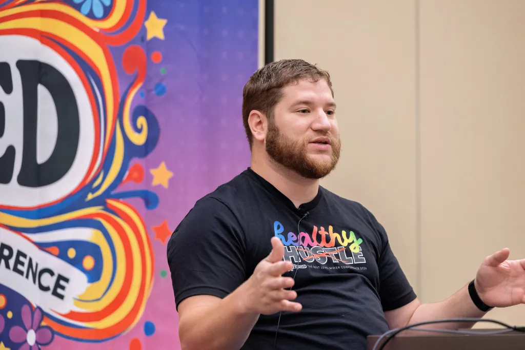 Patrick Campanale speaking and gesturing during a session at the 2026 Next Level Maker Conference.